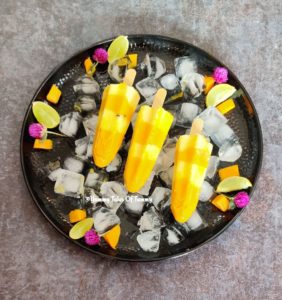 Mango Vanilla Custard Popsicles in round black plate