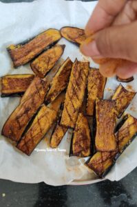 Fried long Brinjals placed on white tissue paper