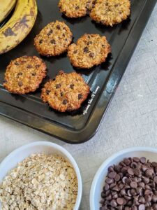 Side shot of 5 ingredient vegan cookies on a black baking tray