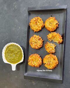 Air fryer Sabudana Vada served in a black tray with green chutney on the side 