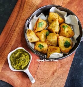 Air fryer frozen Samosa served in black bowl with Dhania pudina chutney on the side 