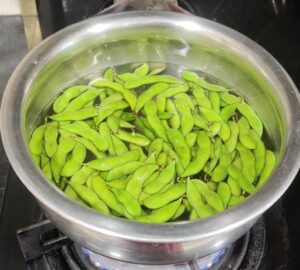 Boiling pot of water with edamame 
