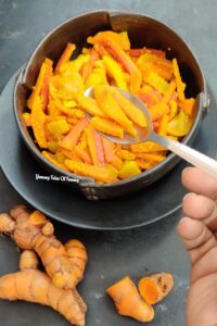 Top view of Fresh Turmeric Pickle | Kachi Haldi ka Achar served in black bowl 