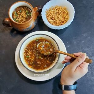 Manchow soup served with dry noodles on the side and a bowl of soup