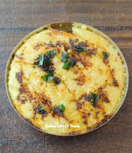 Steamed Khaman in steel plate with tempering on top