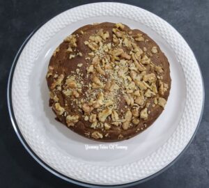 Eggless whole wheat date walnut cake (vegan) placed on a white serving plate 