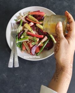 Easy Winter Salad Recipe served on white platter with drizzle of salad dressing 