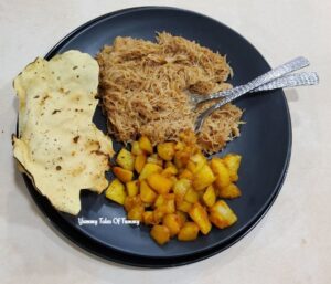 Seyun Patata | Seviyan Alu | Sweet Vermicelli with Potato served on black plate along with roasted papad