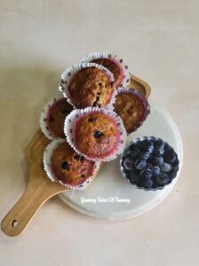 Air Fryer Vegan Banana Blueberry Muffins placed on white marble top with blueberries on the side 