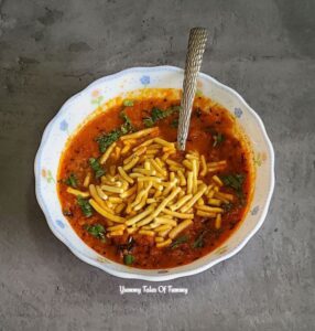 Gujarati Sev tomato sabzi served in a while bowl