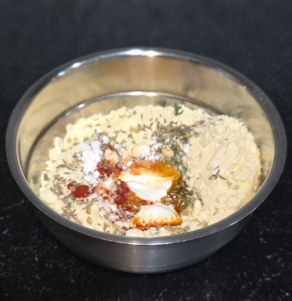 Besan/gram flour with curd and spices to make Rajasthani Gatte ki Sabzi