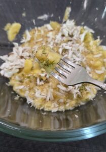 Mashed bananas, grated fresh coconut and fennel seeds in a bowl 
