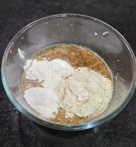 Rice flour and whole wheat flour added to jaggery water mixture 