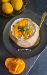Mango Tadgola Coconut Summer Cooler served in a coconut shell