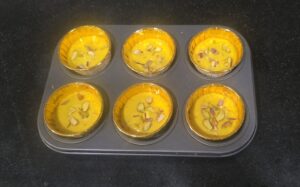 Batter filled till half in muffin molds