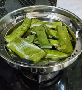 sweet potato, coconut, and jaggery mixture wrapped and steamed in a banana leaf